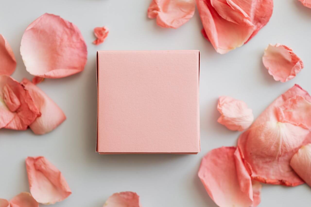 Pink unwrapped gift with pink rose petals